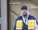 Man i hip hop style med keps och färgglad jacka.