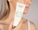 En kvinna håller en tub med Apoliva Vitamin A Nattmask. Produkten innehåller retinol och niacinamid, bra för att minska ålderstecken och motverka akne.