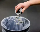 En hand tömmer snusdosan i en papperskorg. Ett steg för att sluta snusa.