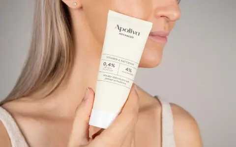 En kvinna håller en tub med Apoliva Vitamin A Nattmask. Produkten innehåller retinol och niacinamid, bra för att minska ålderstecken och motverka akne.