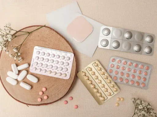 Piller och ett plåster, kanske för klimakteriet medicin. Blommor och trä ger en naturlig känsla.