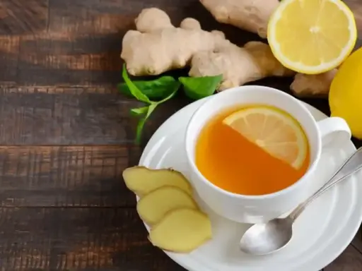 En kopp ingefärste med citron och honung, omgiven av färsk ingefära och citron. Perfekt för en hosta.
