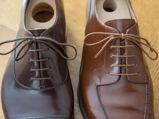 Två par eleganta bruna läderskor, redo att knyta finskor för en fin tillställning.