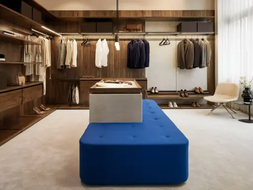 En lyxig walk-in-closet med mörka trädetaljer och en blå sittbänk, allt i en elegant italiensk stil.