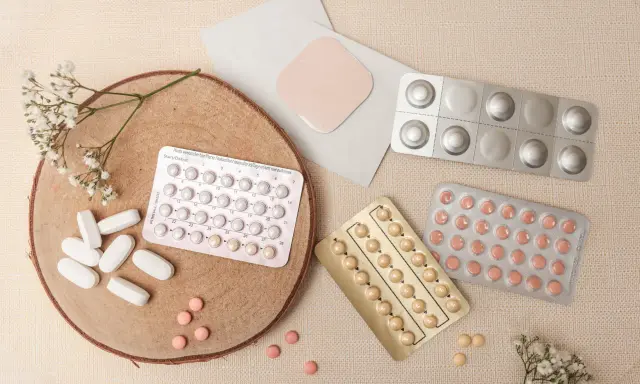 Piller och ett plåster, kanske för klimakteriet medicin. Blommor och trä ger en naturlig känsla.