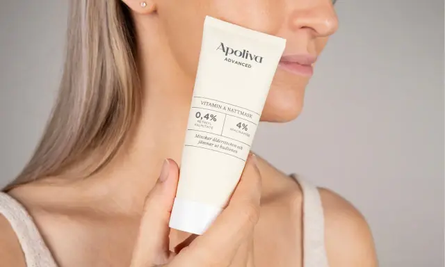 En kvinna håller en tub med Apoliva Vitamin A Nattmask. Produkten innehåller retinol och niacinamid, bra för att minska ålderstecken och motverka akne.