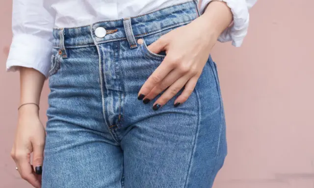 En hand vilar i fickan på ett par ljusblå jeans. Kanske är det en ny trend, jeans i frysen, för att få dem extra krispiga?