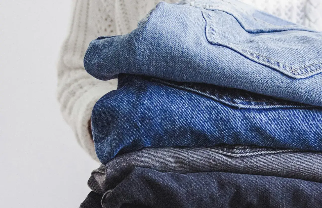 En h&ouml;g med jeans i olika bl&aring; nyanser, redo f&ouml;r jeans &aring;tervinning.