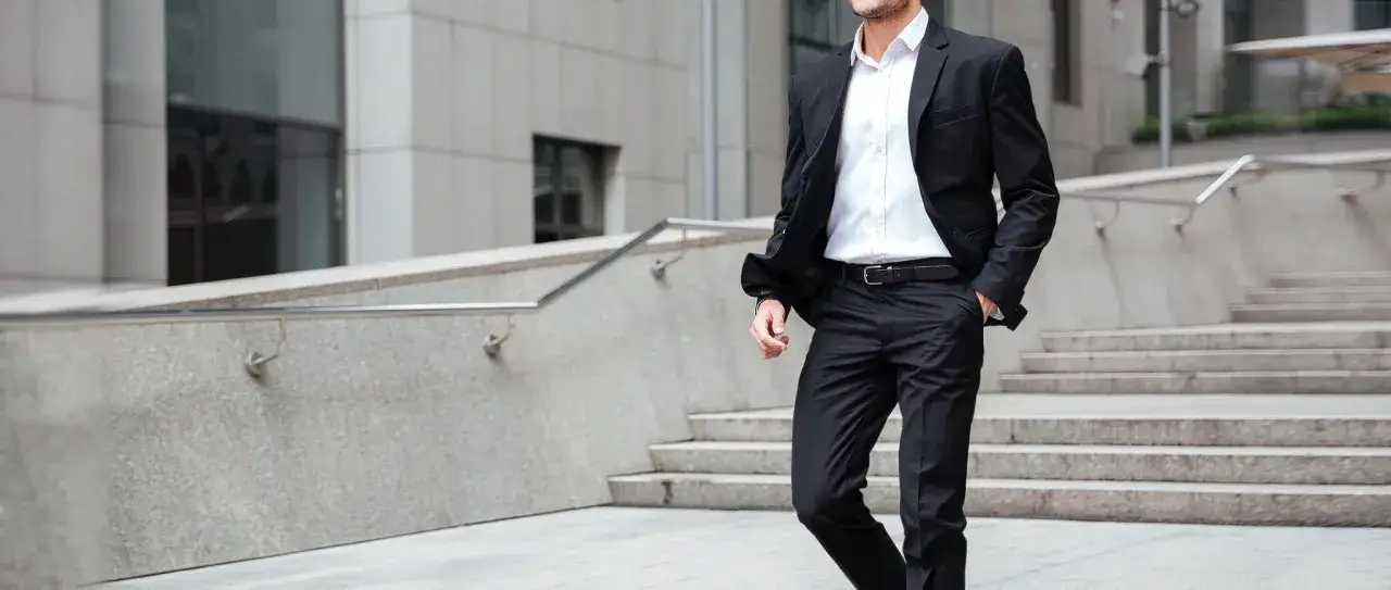 Man i kostym utan slips g&aring;r nerf&ouml;r trappor. En modern och stilren look f&ouml;r aff&auml;rsmannen.